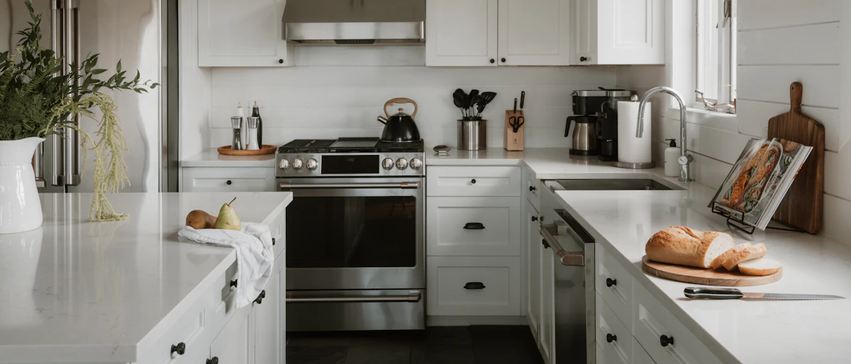 Bright, clean modern kitchen with white cabinets and stainless steel appliances
