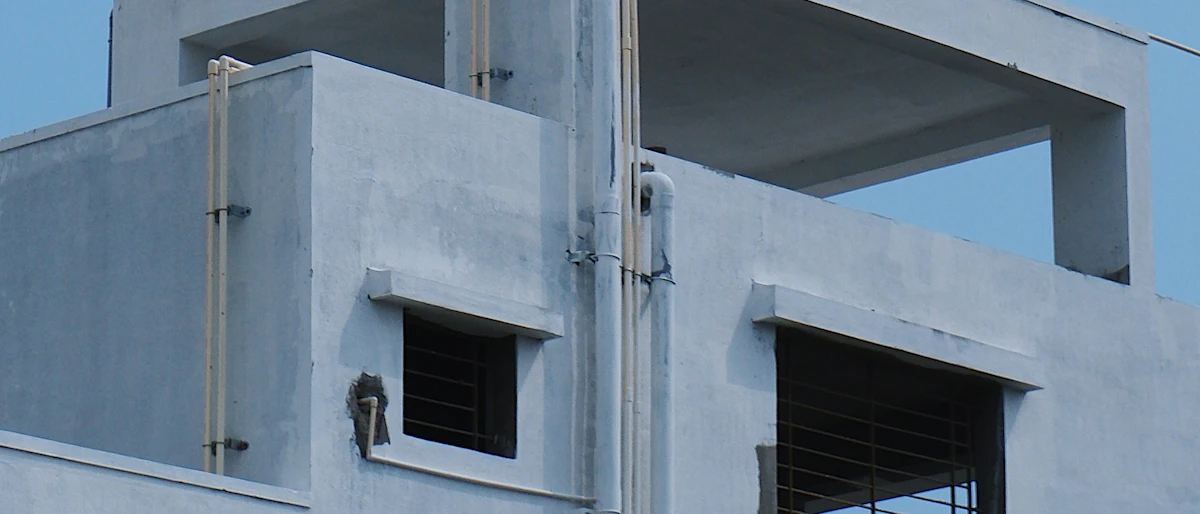 Rooftop water tank mounted on a residential building against a blue sky